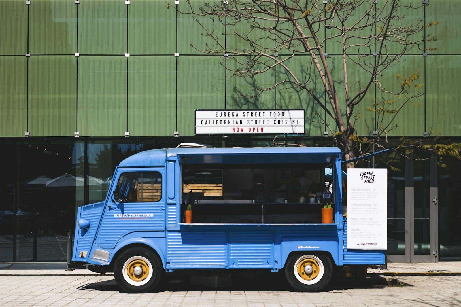 Food truck azul estacionado junto a um edifício