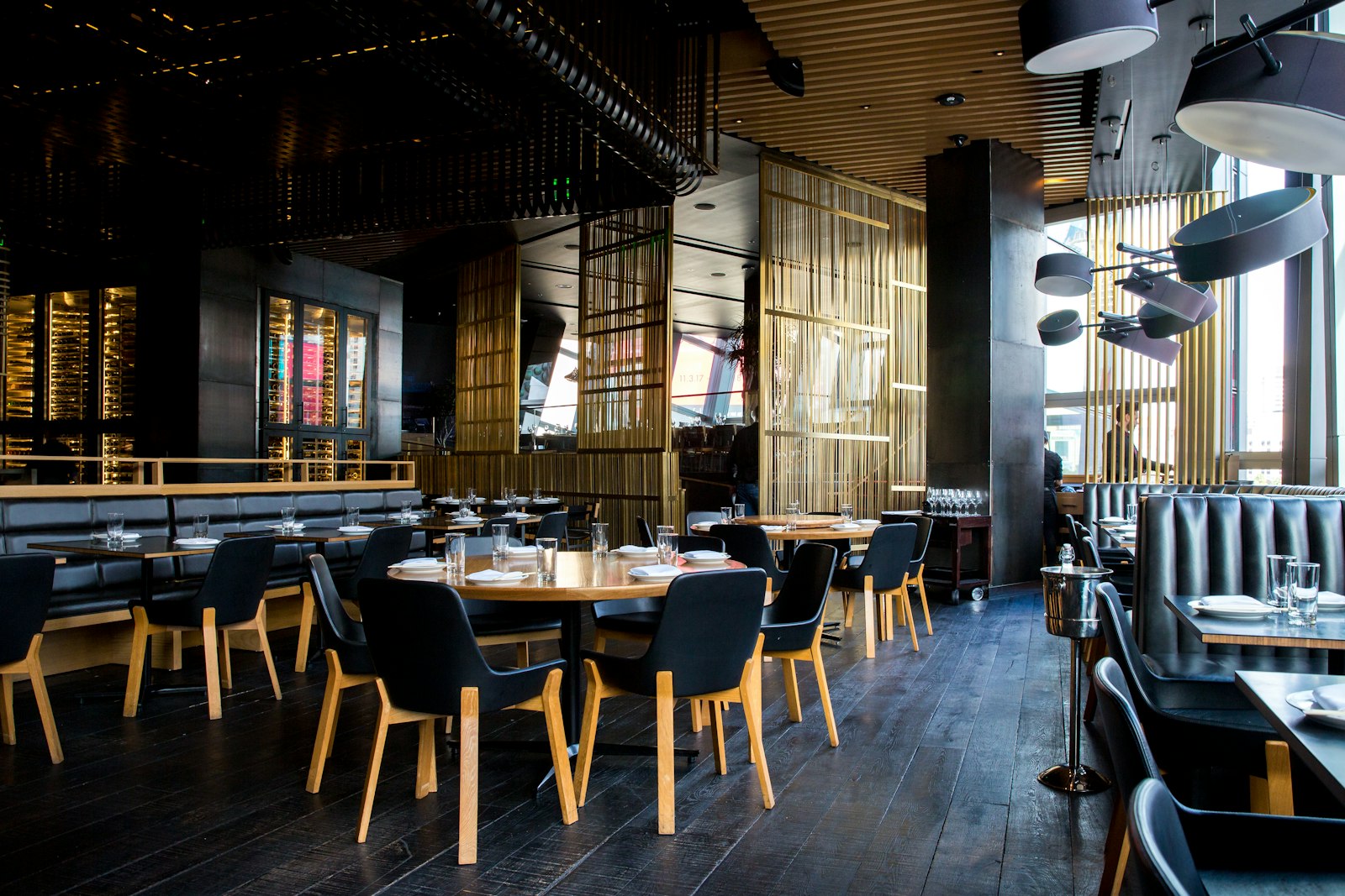Interior de um restaurante com mesas postas e candeeiros suspensos